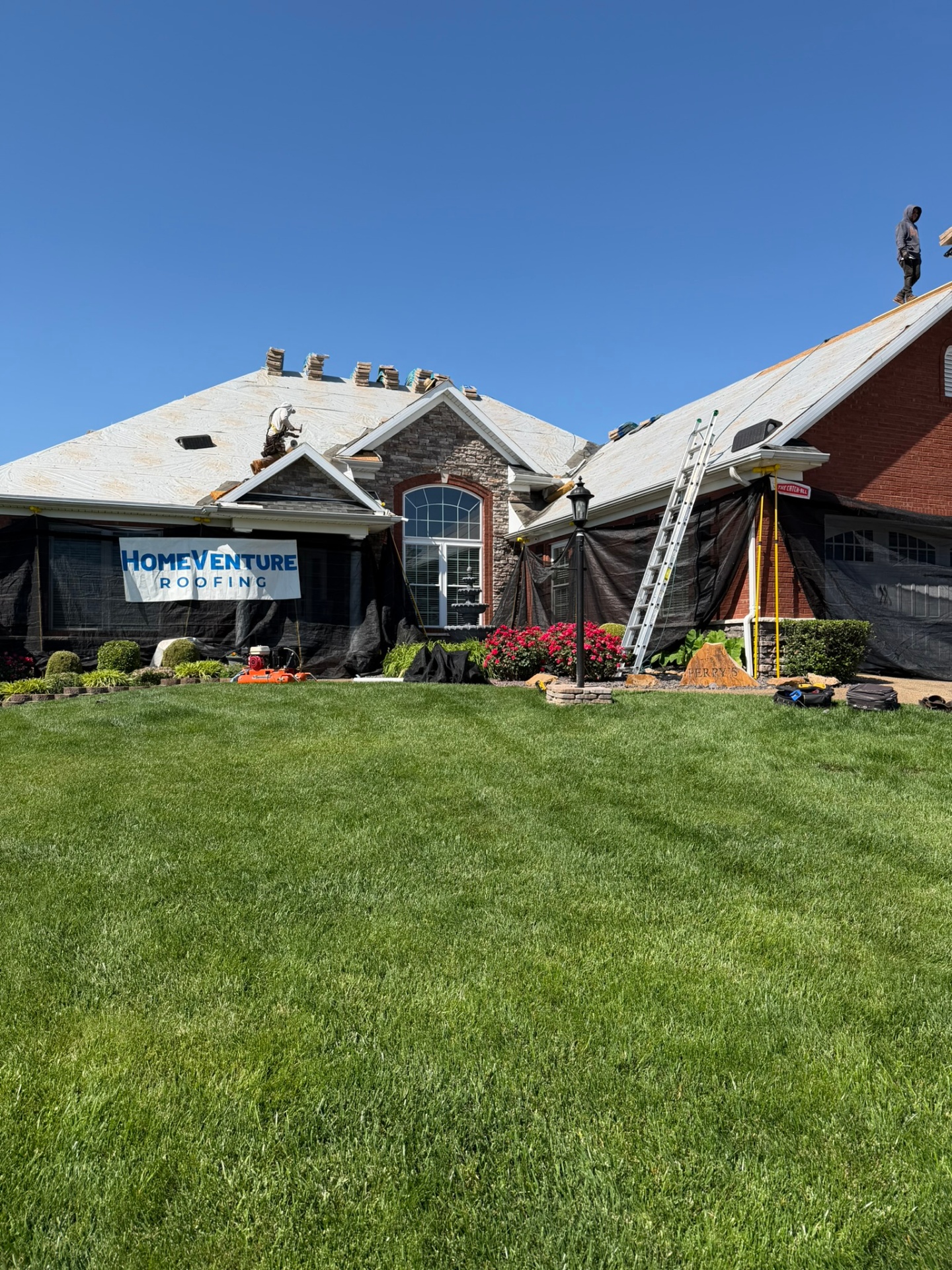 Mesh protection ground to roofline on an Evansville home before tear-off.