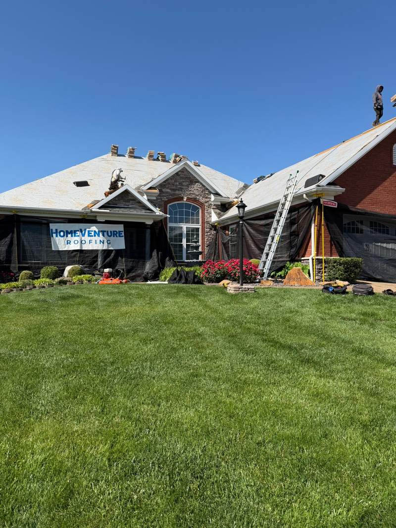 Mesh protection ground to roofline on an Evansville home before tear-off.